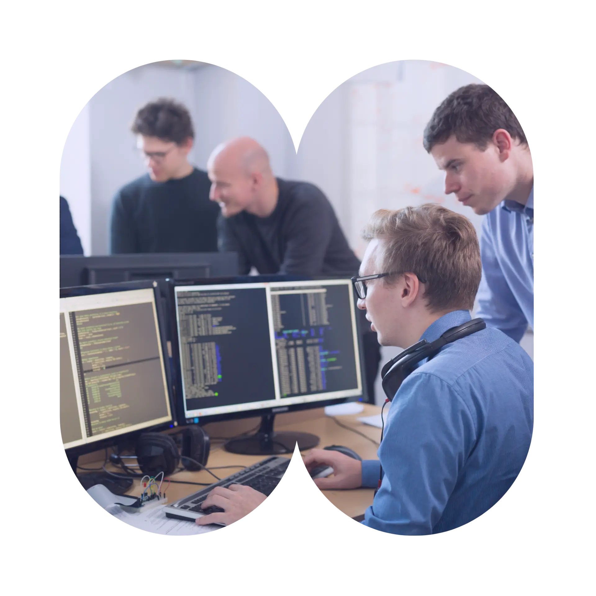 A team gathered around a colleague working at a computer