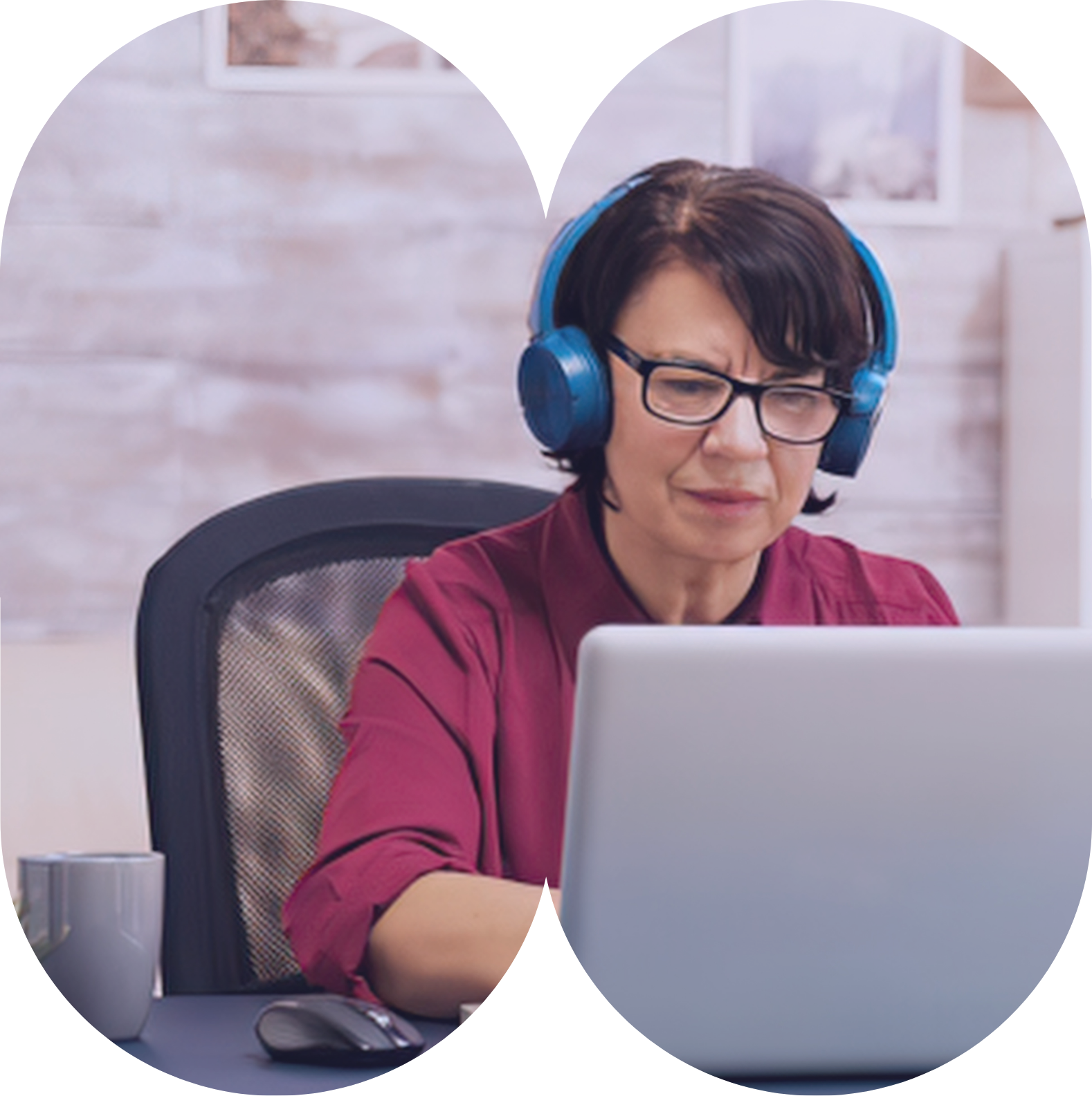 A professional wearing headphones working at a laptop